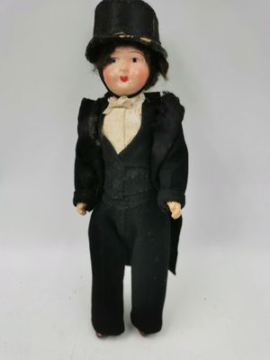 une poupée noire portant un haut-de-forme et un costume noir