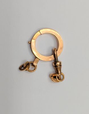 a gold keychain with a chain attached to it