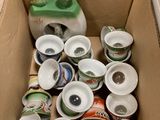 a cardboard box filled with cups and a jug