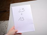 a person holding a piece of paper with a number on it