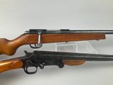 two guns are sitting side by side on a white surface