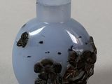 a small glass bottle with a bird on it
