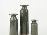 three vases sitting next to each other on a white surface