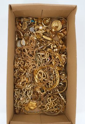 a box full of gold jewelry on a white surface
