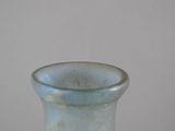 a blue vase sitting on a table with a white wall in the background
