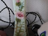 a vase with flowers painted on it sitting on a table