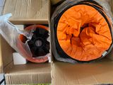 un sac orange et un tuyau noir dans une boîte en carton