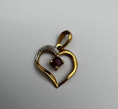 Un pendentif cœur or jaune 18k et petit rubis 0,7 g brut