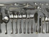 a lot of spoons and spoon knives on the table