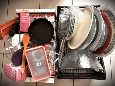 many plates and pans in a box on the floor