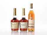 trois bouteilles d'alcool de différentes sortes posées les unes à côté des autres