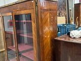 a wooden cabinet with a glass door in the middle of a room