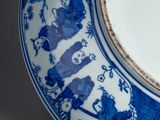 a blue and white plate with a picture of people on it