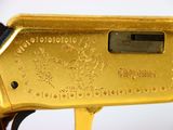a close up of a gold plated rifle on a white background