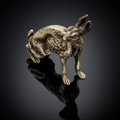 une figurine de lapin dorée posée sur un fond noir