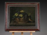 a picture of a painting of grapes in a basket on an easel