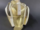 gold and white handbag with a coin on top of it