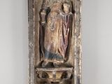 une vieille statue représentant une femme tenant un enfant dans ses bras, posée sur une étagère