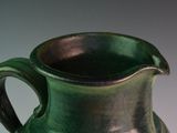 a green vase that is sitting on a table