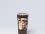 un verre à shot marron et blanc posé sur une table blanche