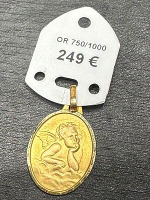 un gros plan d'une médaille d'or à laquelle est attachée une étiquette