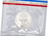 the coin is in a clear plastic bag with a red, white, and blue stripe