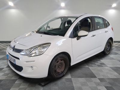 la petite voiture blanche est garée sur un sol en damier