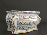 a white vase with blue and yellow designs on it