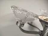 a silver candle holder with a glass bowl on top of it
