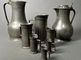 a lot of silver vases and cups sitting on a table