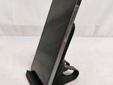 a close up of a cell phone on a stand on a bed