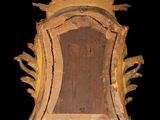a wooden mirror with a gold frame on a black background