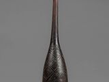 a black vase sitting on top of a table next to a gray wall