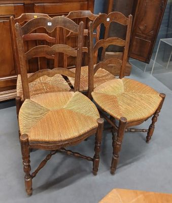 une paire de chaises en bois avec des assises en osier dans une pièce