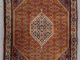 an antique persian rug with a diamond design on a brown ground