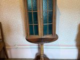 une petite table en bois surmontée d'une porte vitrée