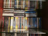 a glass shelf full of dvds and cds in a room