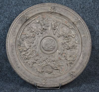 an old silver plate with a design of flowers and leaves