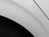 a close up of a white car with scratches on the side of it