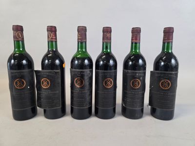 six bottles of wine are lined up in a row on a white surface
