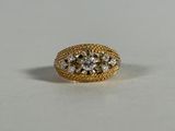 a close up of a gold ring with three diamonds on it