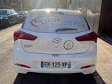 the back of a white car parked on the side of a road