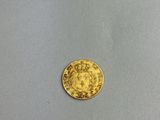 a close up of a gold coin on a white surface