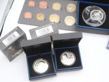 a lot of silver coins in a box on a table