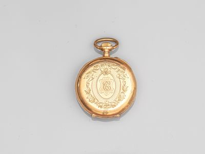 a gold pocket watch on display on a white surface