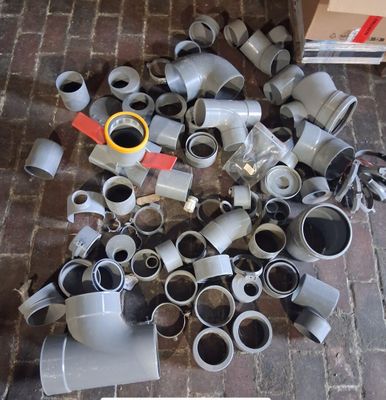 un tas de tuyaux et de raccords par terre