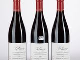 trois bouteilles de vin rouge posées côte à côte sur une table