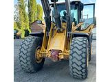 the back end of a yellow tractor parked in a parking lot