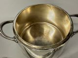 a silver cup with a spoon in it on a table