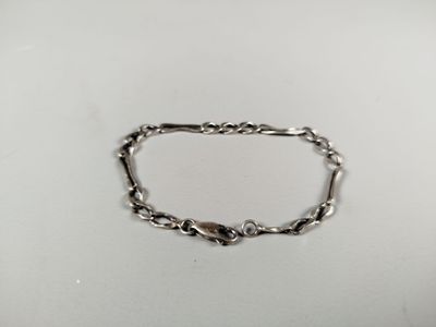 a close up of a silver chain bracelet on a white surface